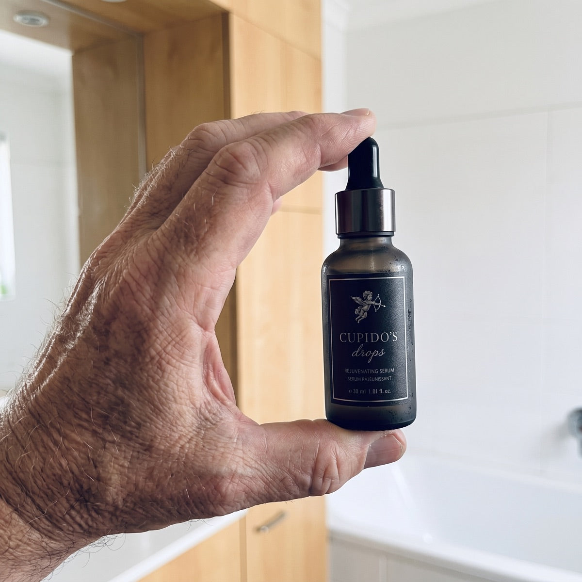 Cupido Drops bottle held at the sink